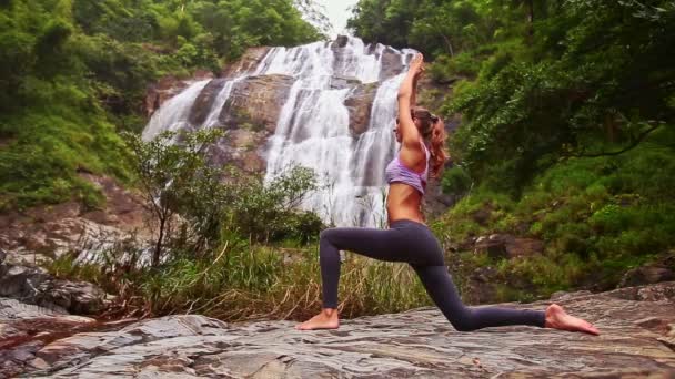 Žena, která dělá jógu poblíž vodopád — Stock video
