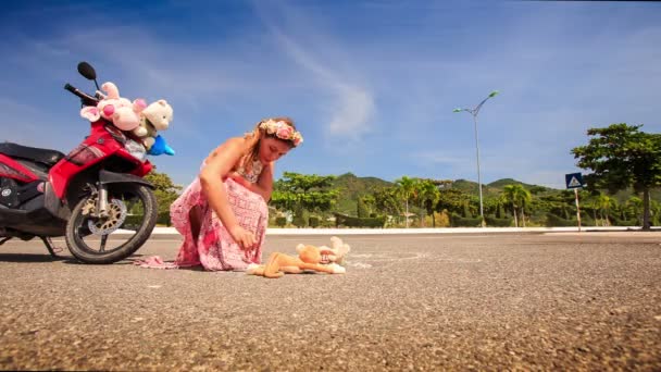 Kvinna drar bilden på asfalt med motorcykel — Stockvideo