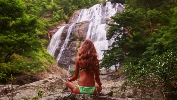 Frau macht Yoga in der Nähe des Wasserfalls — Stockvideo