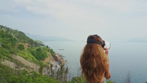 Chica en casco de realidad virtual mirando el paisaje marino — Vídeos de Stock