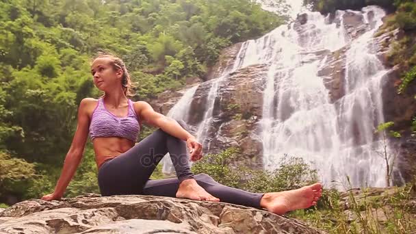 做瑜伽瀑布附近的女人 — 图库视频影像