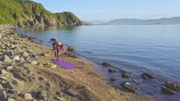 Girl doing yoga on beach coast — Stock Video