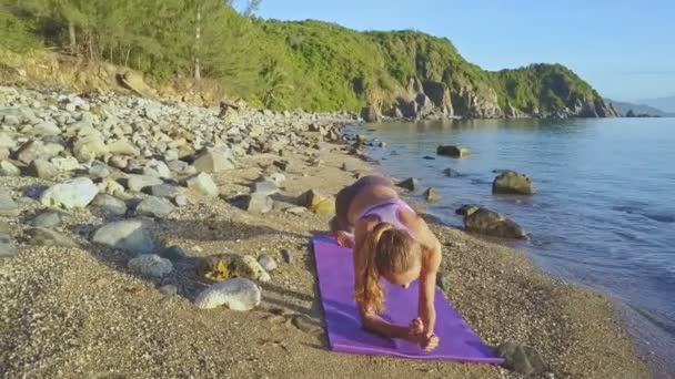 Meisje doet yoga op het strand kust — Stockvideo