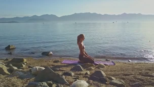 Chica haciendo yoga en playa costa — Vídeo de stock