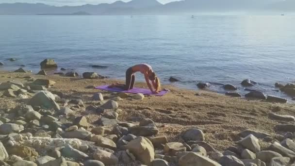 Meisje doet yoga op het strand kust — Stockvideo