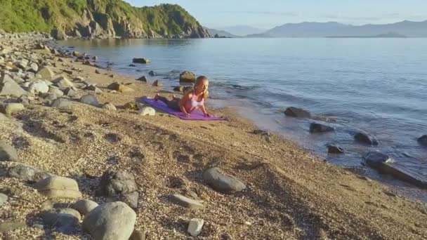Menina fazendo ioga na costa da praia — Vídeo de Stock