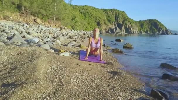 做瑜伽在沙滩海岸上的女孩 — 图库视频影像