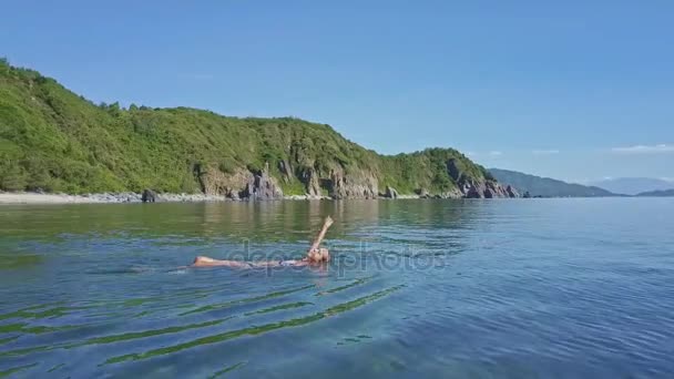 海の水で背中で泳いでいる少女 — ストック動画