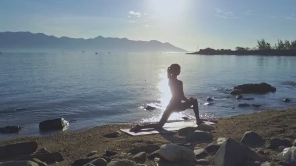 Flicka gör yoga på stranden kusten — Stockvideo