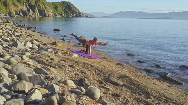 Flicka gör yoga på stranden kusten — Stockvideo