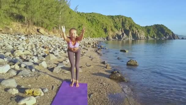 Дівчина робить йогу на узбережжі пляжу — стокове відео