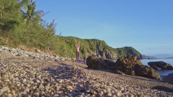 Flicka gör yoga på stranden kusten — Stockvideo