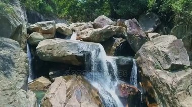 büyük kayaların arasında nehir şelale basamaklandırır