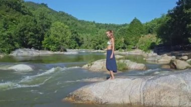 Kız nehir içinde taşlar üzerinde selfie yapar