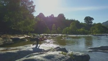 taş nehir kıyısında yoga yaparken kız