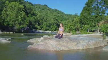 taş nehir kıyısında yoga yaparken kız