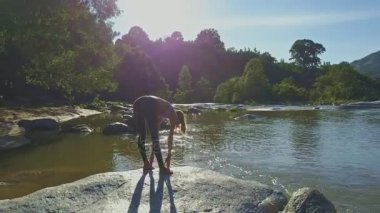 taş nehir kıyısında yoga yaparken kız