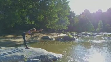 taş nehir kıyısında yoga yaparken kız