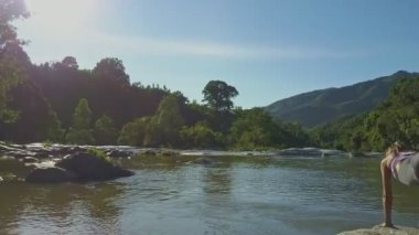taş nehir kıyısında yoga yaparken kız
