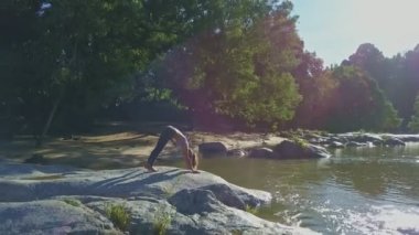 taş nehir kıyısında yoga yaparken kız