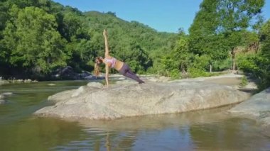 taş nehir kıyısında yoga yaparken kız