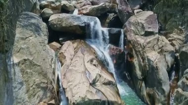 büyük kayaların arasında nehir şelale basamaklandırır