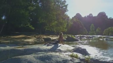 taş nehir kıyısında yoga yaparken kız