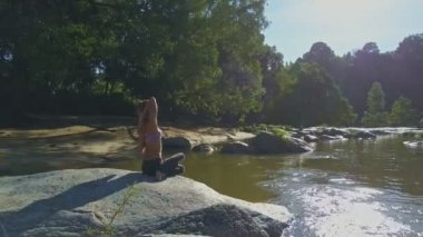 taş nehir kıyısında yoga yaparken kız
