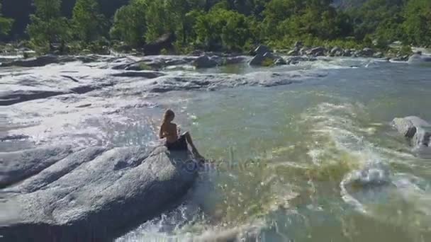 Taş river rapids arasında oturan kız — Stok video