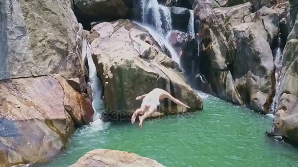 Человек турист прыгает из камня в пресной воде — стоковое видео