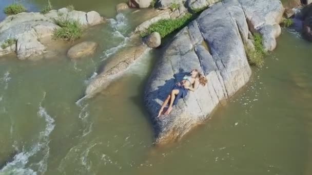Taş river rapids arasında yatan kız — Stok video