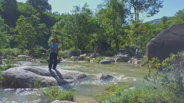 Мужчина рыбачит в горной реке — стоковое видео