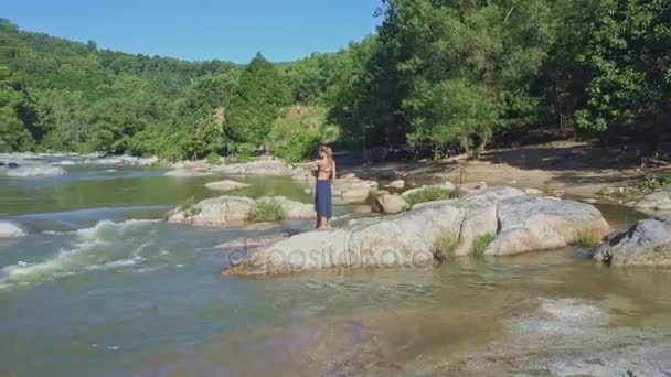 Pareja tomando fotos entre los rápidos del río — Vídeo de stock