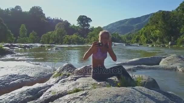 Menina faz selfie em pedras no rio — Vídeo de Stock