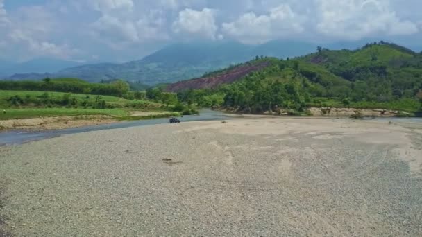 川の近くの砂利で運転軍用ジープ — ストック動画