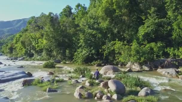 Homem cruzando pedra rio de montanha — Vídeo de Stock