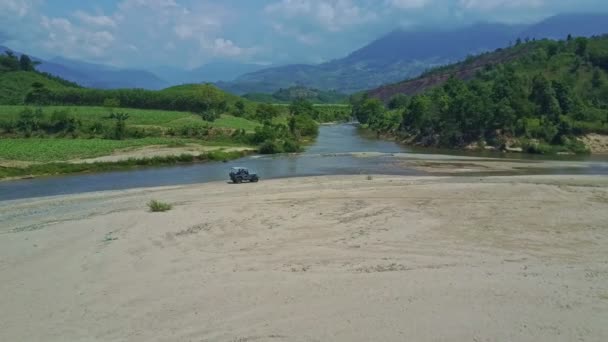 Jeep militar conduciendo sobre grava cerca del río — Vídeos de Stock