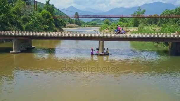 Mujeres lavando ropa en el río bajo el puente — Vídeo de stock