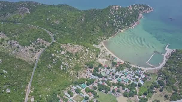 Route le long des collines et village baigné par l'océan — Video