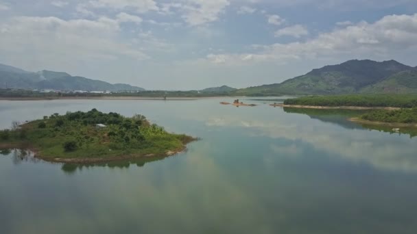 Lake en eilandje tegen heuvellandschap — Stockvideo