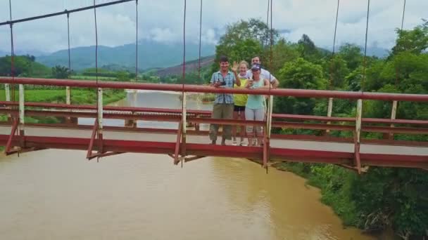 Persone felici in piedi sul ponte moto sul fiume — Video Stock