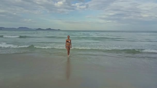 Menina caminha na praia de areia contra o oceano — Vídeo de Stock