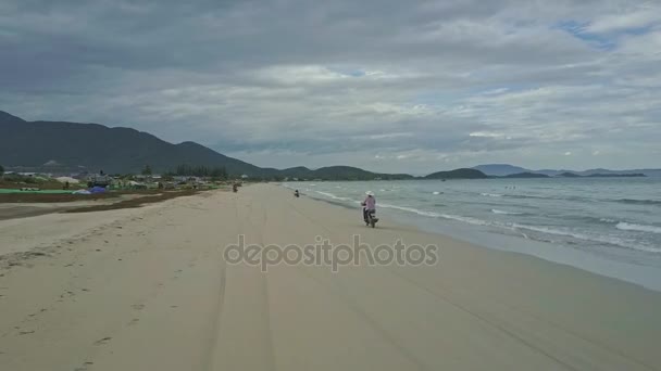 Homem dirigindo moto ao longo praia de areia — Vídeo de Stock