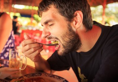 Tablo-kaşık Cafe çiçekli arka plan ile portre sakallı adam yiyor