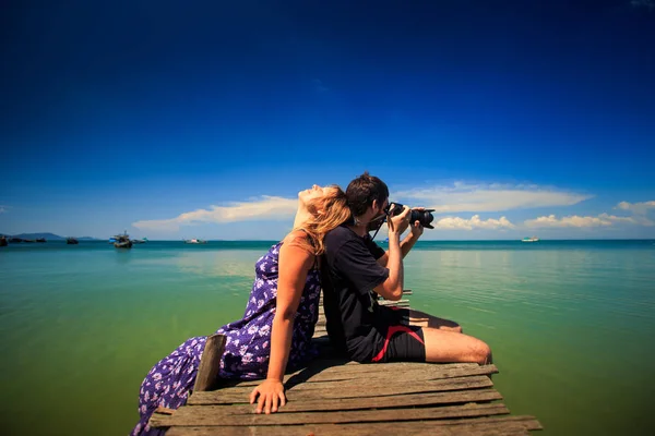 Guy maken foto's met meisje liggend op hem — Stockfoto