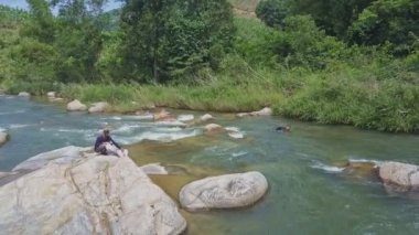nehir kenarındaki taş adam oturur