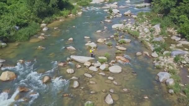 Homem com vara de pesca anda ao longo do rio — Vídeo de Stock