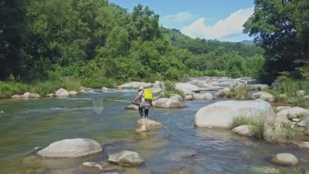 Man met hengel wandelingen langs de rivier — Stockvideo