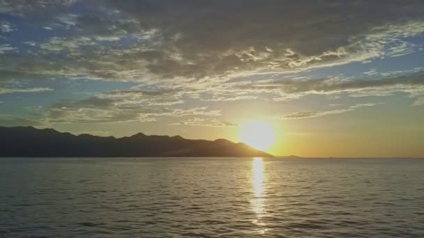 Zonsopgang boven rustige Oceaan tegen verre heuvels — Stockvideo