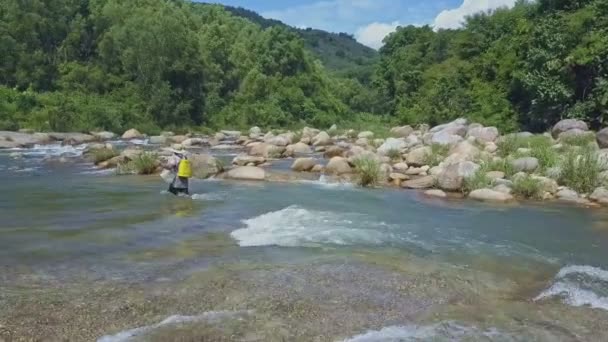 Людина з рибальським стрижнем ходить вздовж річки — стокове відео